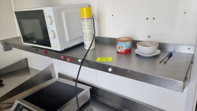une photo d'une cuisine équipée d'un micro-ondes et d'une cuisinière