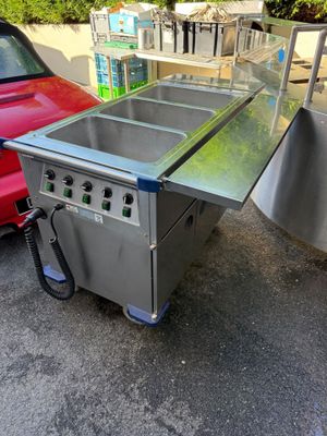 two stainless steel sinks are sitting in a parking lot next to a red car