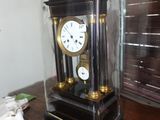une horloge posée sur une table, protégée par une vitre