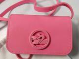 the pink purse is sitting on top of a white cloth