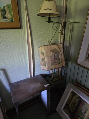 une photo d'un coin de pièce avec une lampe et des tableaux accrochés au mur