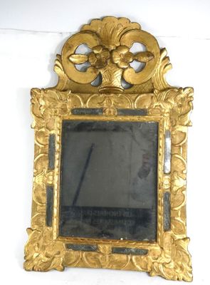 a gold frame with a mirror in it on the wall