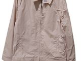 a beige jacket hanging on a hanger on a white wall