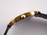 a close up of a watch on a white surface with a black strap