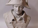 statue of a man wearing a hat with a feather on top of it