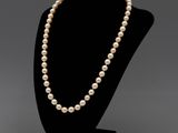 un collier de perles blanches sur un mannequin noir
