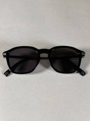 une paire de lunettes de soleil noires posée sur une table blanche