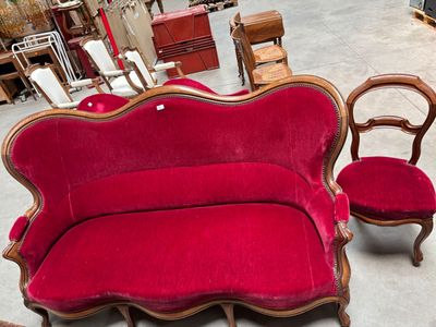 un canapé rouge et deux fauteuils dans une pièce