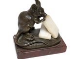 statue of a mouse eating a piece of cheese on a marble base