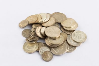 a pile of coins sitting on a white surface