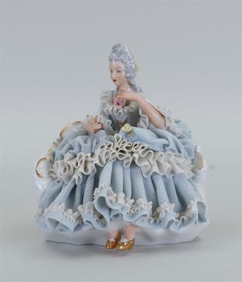 figurine en porcelaine représentant une femme en robe bleue tenant une fleur