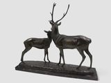 bronze sculpture of two deers standing next to each other on a table