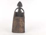 an old wooden bell with a woman sitting on top of it