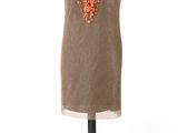 robe marron posée sur un mannequin, ornée de perles orange et d'un collier
