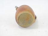 a brown cup with a handle sitting on a white surface