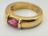 une image d'une bague en or avec une pierre rose au centre