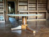 une table au milieu d'une pièce, avec des bibliothèques en arrière-plan