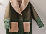 coat hanging on a hanger on a wall with a coat on it