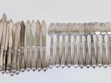 a lot of silverware on a white table