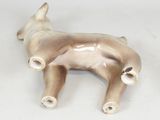 a figurine of a dog laying down on a white surface