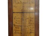 an old wooden wall mounted thermometer with writing on it