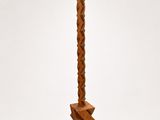 an image of a tall wooden candle holder with a candle on top