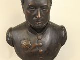 statue of a bust of a man with a flower on his chest
