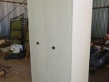 a white cabinet in a warehouse with a door open