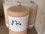 une bougie posée sur une étagère à côté de quelques rouleaux de papier toilette