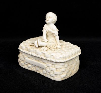 white porcelain figurine of a boy sitting on top of a brick box