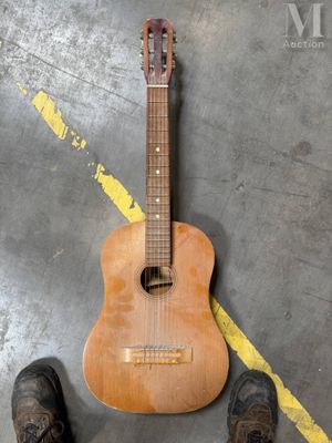 someone is standing next to a guitar that is on the ground