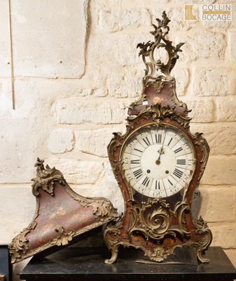 une horloge posée sur une table, à côté d'une paire de chaussures