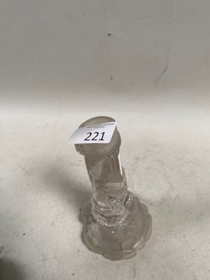 un petit bougeoir en verre sur lequel est collé un autocollant