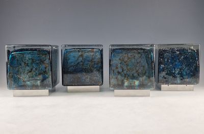 trois blocs de verre carrés contenant des billes bleues et vertes