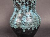 a blue and black vase sitting on a table