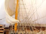 model of a wooden ship with sails and ropes on display