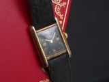 an image of a wrist watch with a red book in the background