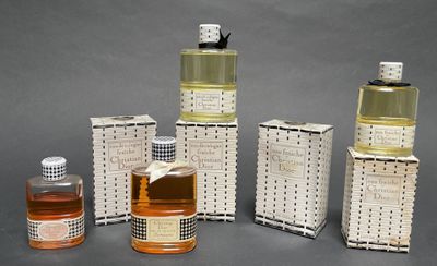 several bottles of perfume are lined up on a gray surface
