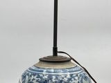 a blue and white vase with a lamp on it