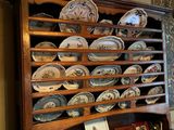 a wooden cabinet with many plates on top of it