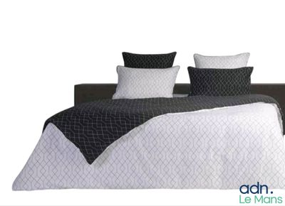 a bed with a black and white comforter and two pillows