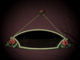 a mirror hanging on the wall with roses on it