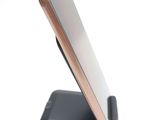 a cell phone that is on a stand on a white surface