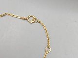 a close up of a gold chain bracelet on a white surface