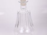 Flacon de parfum en verre transparent muni d'un bouchon en verre, sur fond blanc