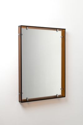 un miroir accroché au mur au-dessus d'un lavabo