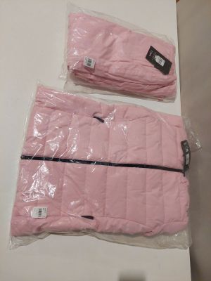 Deux sacs de vêtements roses sont posés sur une table blanche