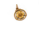 a close up of a gold pendant with a flower on it