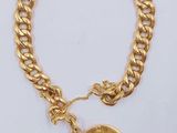 un bracelet en or orné d'un pendentif en forme de pièce de monnaie