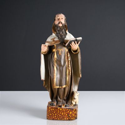 une statue représentant un homme tenant un livre et un chien